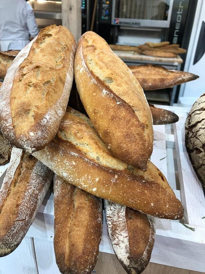 Baguettes et pains alignés à la sortie du four